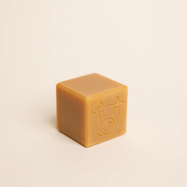 Close-up of Paca Botanica Marigold Brightening Soap Bar with turmeric and calendula, showcasing its rich golden hue.