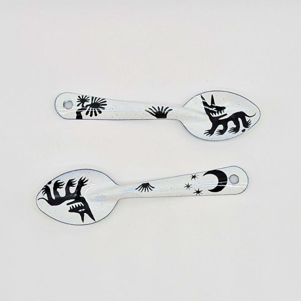 set of two stylized dog or wolf-like creatures (nahual) with sharp teeth and distinctive features on the enamelware peltre metal spoon