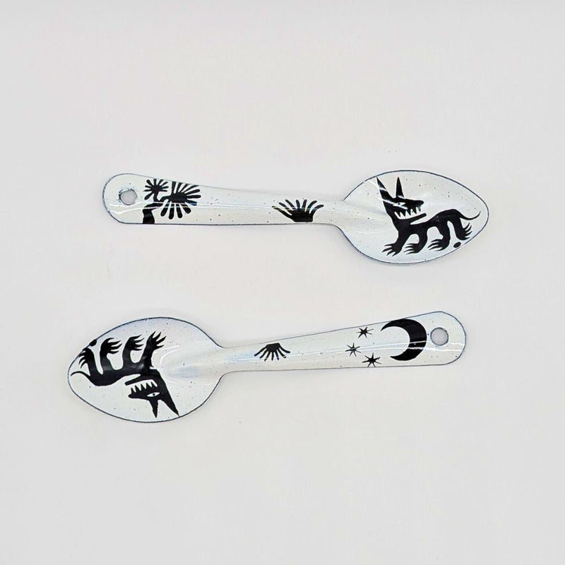 set of two stylized dog or wolf-like creatures (nahual) with sharp teeth and distinctive features on the enamelware peltre metal spoon