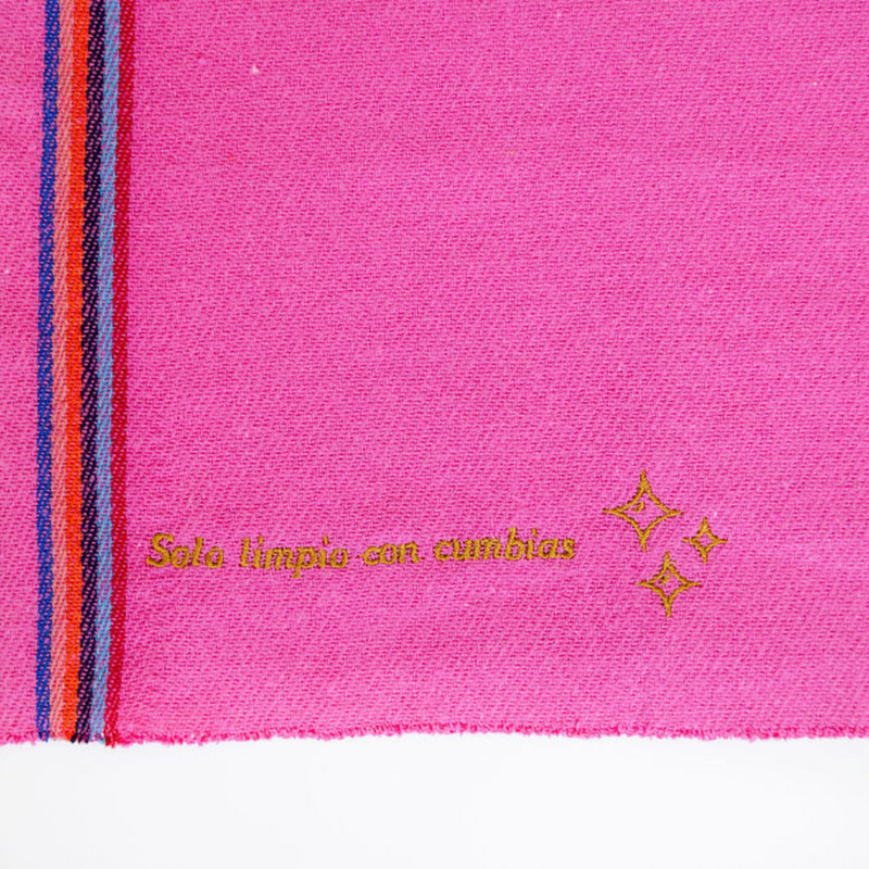 Close up of a fuchsia pink recycled cotton cleaning cloth reading "Solo limpio con cumbias"