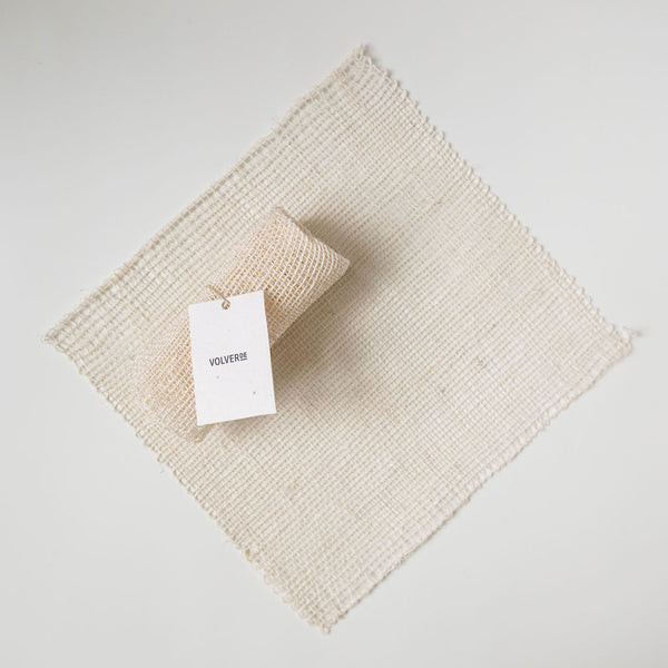 Agave Fiber Washcloth (Ayate) square waschloth laying flat with a rolled up ayate on top of it on a white background.