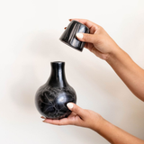 handcrafted black ceramic bottle carafe with decorative patterns on a white background