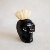 Black Obsidian Skull Candle with a white flower top, made from 100% beeswax, perfect for home decor or altars, offering a unique blend of bold design and natural elements.