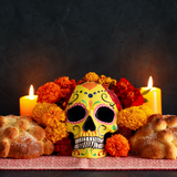 Dia de Muertos (day of the dead) ofrenda with cempasuchil (marigold) flowers scattered around a skull and pan de muerto