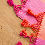 Color Block Pink and Orange Cotton Table Runner with tassels on wood table view of tassels