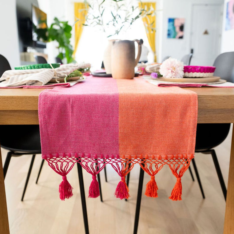 Color Block Pink and Orange Cotton Table Runner with tassels on dinning table styled with dinnerware