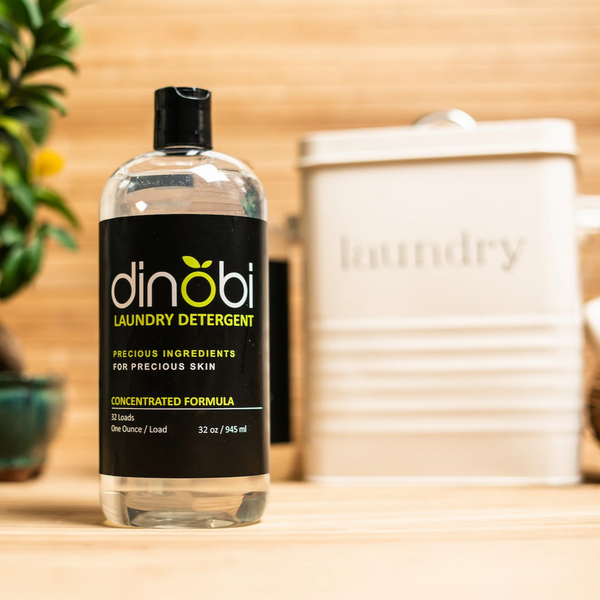 Dinobi nontoxic laundry detergent in front of a laundry tin