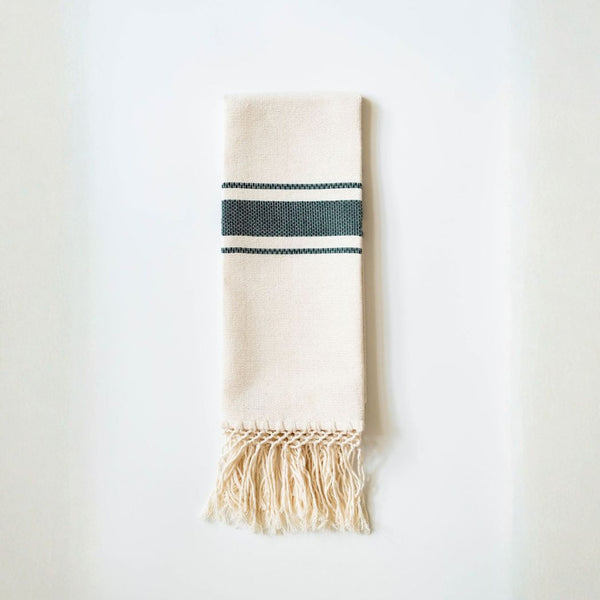 Beige towel with hunter green stripes and fringes on a white background