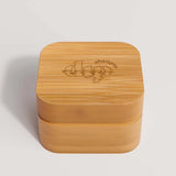 Eco-friendly bamboo travel case with a lined lid and inner coaster, designed to protect and dry a full-sized shampoo bar during travel.