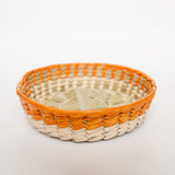 Side view of Mexican woven palm basket with Orange (Apricot) color rim and natural bottom