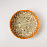 Top view of Mexican palm basket with Orange (Apricot) color rim and natural bottom on white background
