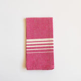A vibrant Rosa Mexicano (Pink) Casa Oaxaca Woven Cotton Napkin, showcasing artisanal craftsmanship from Oaxaca, Mexico, with a soft, durable texture perfect for adding a pop of color to any table setting. This eco-friendly, 100% cotton napkin is handwoven, blending sustainable design with traditional Mexican culture.