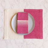 Rosa mexicano pink cotton woven napkins with white stripes on a matching placemat
