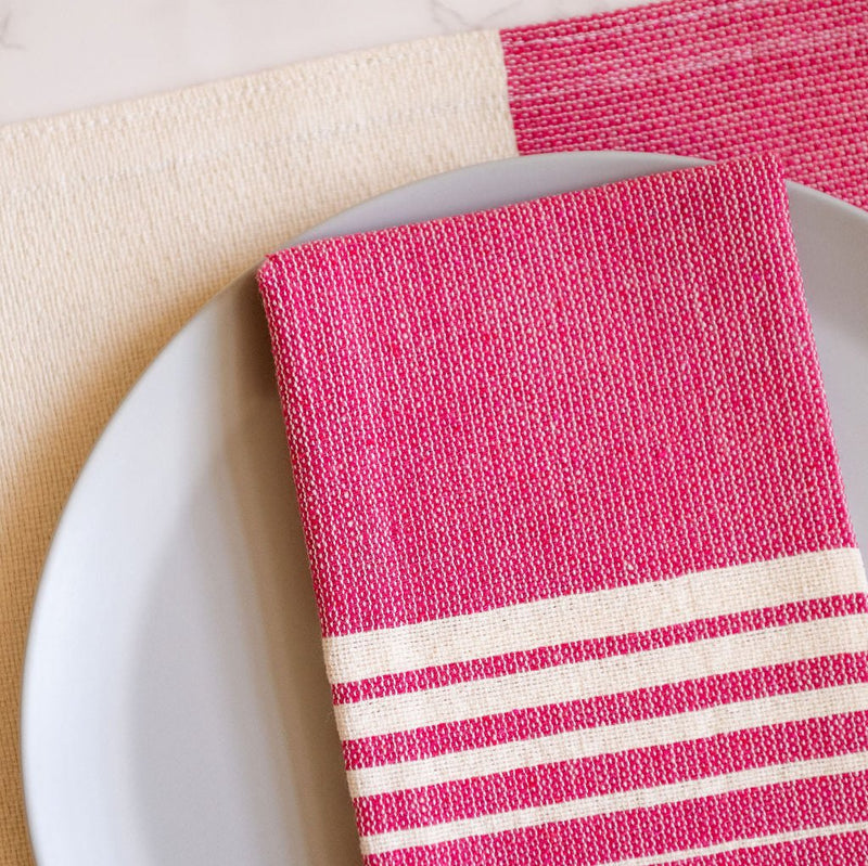 Closeup of rosa mexicano pink cotton woven napkins with white stripes