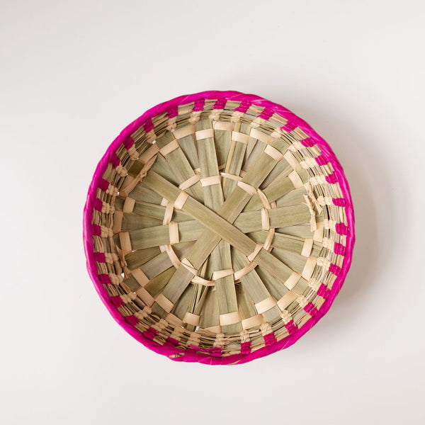 Overhead view of Mexican palm basket with a pink color rim (Rosa Mexicano) and natural bottom