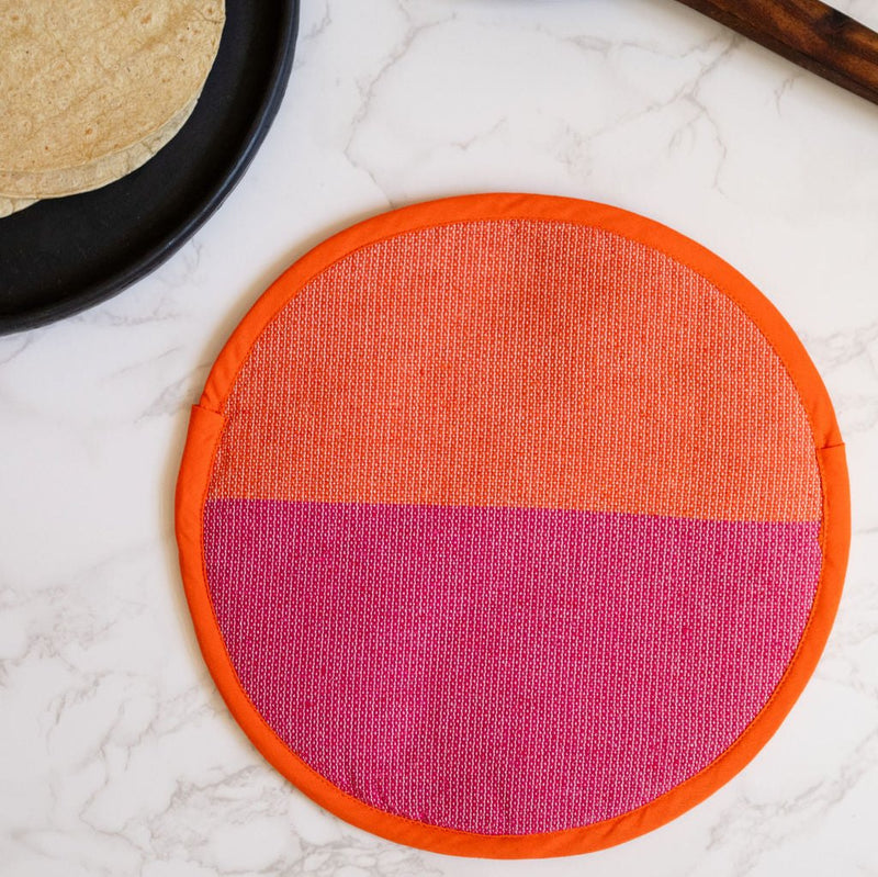 A vibrant Rosa Mexicano pink and orange color block handwoven cotton tortilla warmer, perfect for keeping tortillas warm while adding a pop of color to your table. This eco-friendly, artisan-made kitchen accessory is crafted from sustainable materials, reflecting Mexican cultural heritage and zero-waste values.