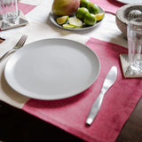 Rosa Mexicano (magenta) placemat with neutral color block placemat with a plate of mango and limon