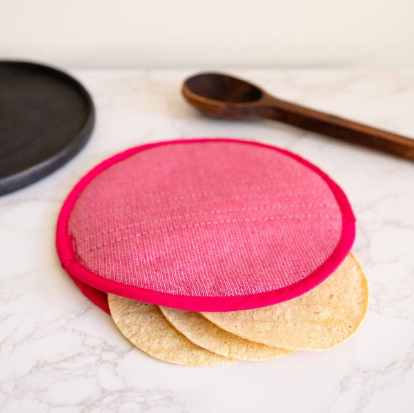 A vibrant Rosa Mexicano pink color block handwoven cotton tortilla warmer, perfect for keeping tortillas warm while adding a pop of color to your table. This eco-friendly, artisan-made kitchen accessory is crafted from sustainable materials, reflecting Mexican cultural heritage and zero-waste values.