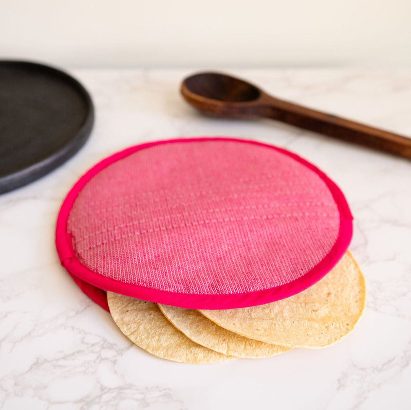 A vibrant Rosa Mexicano pink color block handwoven cotton tortilla warmer, perfect for keeping tortillas warm while adding a pop of color to your table. This eco-friendly, artisan-made kitchen accessory is crafted from sustainable materials, reflecting Mexican cultural heritage and zero-waste values.