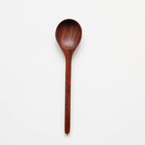 A hand-carved Rosewood Cooking Spoon with a deep, smoothly curved bowl and a gracefully elongated handle.