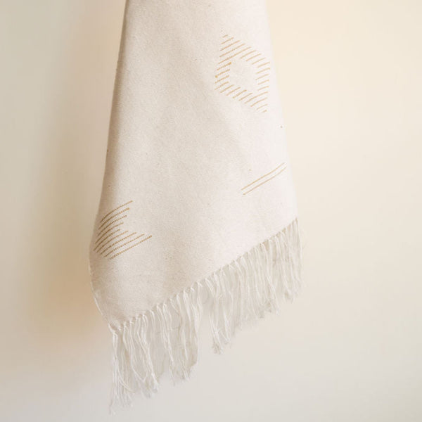 Beige 100% cotton hand towel with gold geometric lines and cotton fringe detail