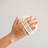 Back side of Natural Agave Body Sponge with a strap on a hand for ergonomic hold