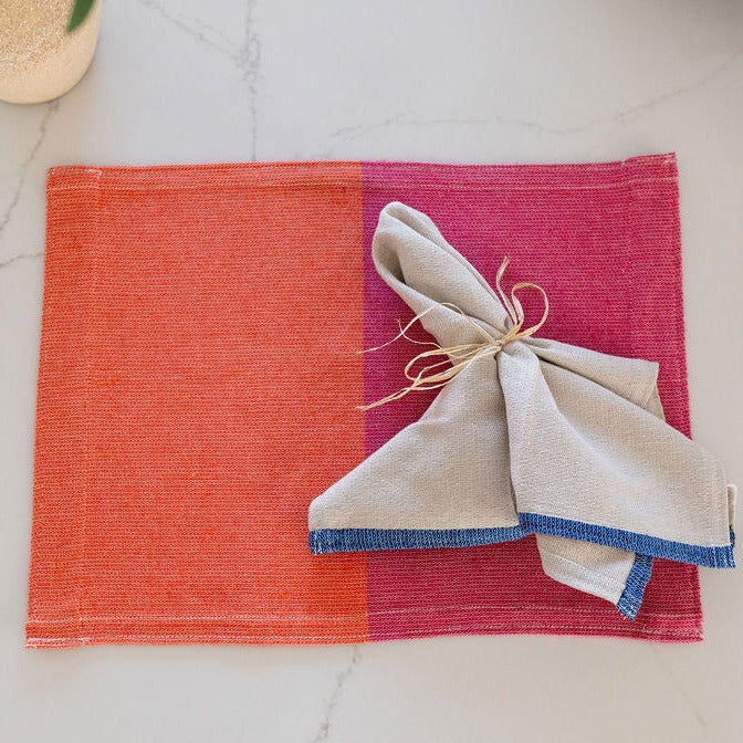 Pink and orange placemat with oversized dinner napkin with blue border