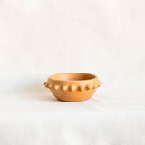 Terracotta ceramic clay (barro) bowl with pointed  spike rim on a white background