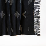 Sacred Lines Handwoven Cotton Table Runner in Black with white geometric patterns and fringe on a white background
