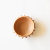 Terracotta ceramic clay (barro) bowl with pointed  spike rim on a white background