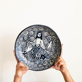 Handmade mermaid ceramic serving platter from Tzintzuntzan Michoacán, black and white burnished clay pottery with hand illustrated mermaid and wave pattern being held by hands