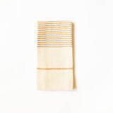 A folded cream-colored linen tea towel with horizontal terracotta stripes near the top and bottom, displayed on a clean white background.