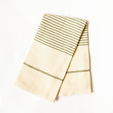 A folded cream-colored cotton kitchen towel with olive green striped borders, displayed on a clean white background.