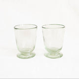 Two clear Mexican blown glass tumblers with footed bases, shown side by side on a plain white background.