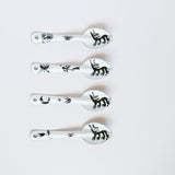 set of four stylized dog or wolf-like creature (nahual) with sharp teeth and distinctive features on the enamelware peltre metal spoon