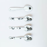 set of four stylized dog or wolf-like creature (nahual) with sharp teeth and distinctive features on the enamelware peltre metal spoon