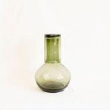 olive green glass round carafe with lid on a white background