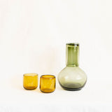 Set of handblown mexican green and amber glassware on a white background