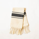 Beige handwoven cotton hand towel with black stripes and cotton fringe