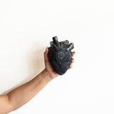 Hand Holding a Mexican Barro Negro Ceramic Anatomical Heart Wall Art Sculpture