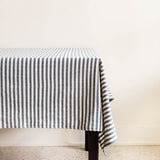 Hunter green striped cotton woven tablecloth on a table against neutral background