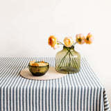 Table setting with large handblown olive green glass vase and olive green glass bowl with tortilla chips