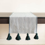 Hunter Green Striped Cotton Table Runner with large green tassels on a dark table