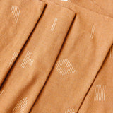 Close up of terracotta cotton woven table runner with white geometric woven figures from Mitla, Oaxaca