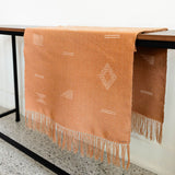Terracotta cotton woven table runner hanging on a console table