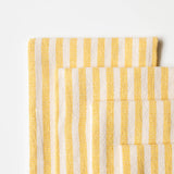 Yellow and white striped cloth dinner napkins on white background