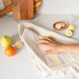 Beige and yellow cotton hand towel used to wipe down counter with guava and oranges in background
