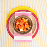 Border Accent sustainable Palm Round Placemat in pink styled with a cotton pink, yellow stripe napkin and yellow placemat.