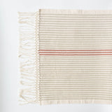 A Corded Handwoven Cotton Hand & Tea Towel with three cinnamon stripes hanging from a hand.
