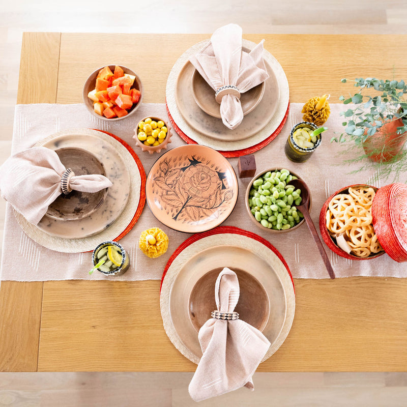 Cotton Table Runner styled with plates palm placemats and ceramic fruit plate with recycled glass. 